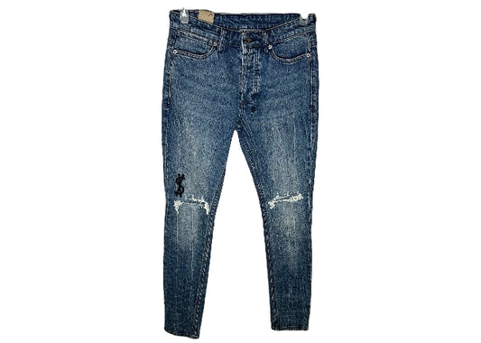 KSUBI blue acid wash ripped jeans with knee holes & black dollar sign embroidery.