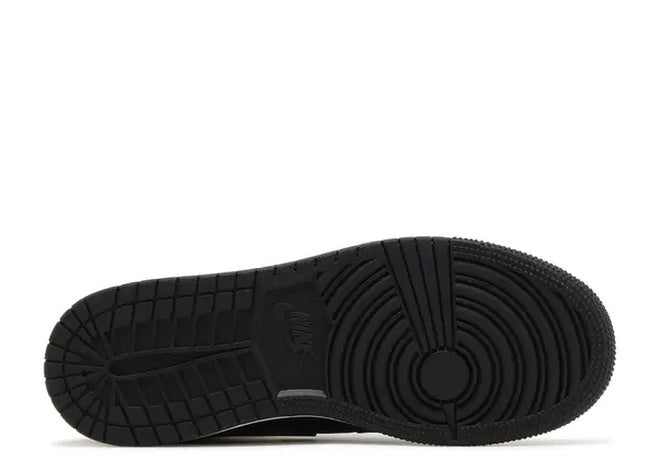 Black Jordan Air Jordan 1 Mid GS basketball shoe sole with Nike logo and traction pattern.