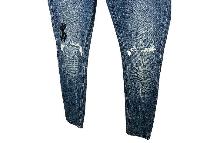 KSUBI distressed blue jeans with dollar sign embroidery and knee rips.