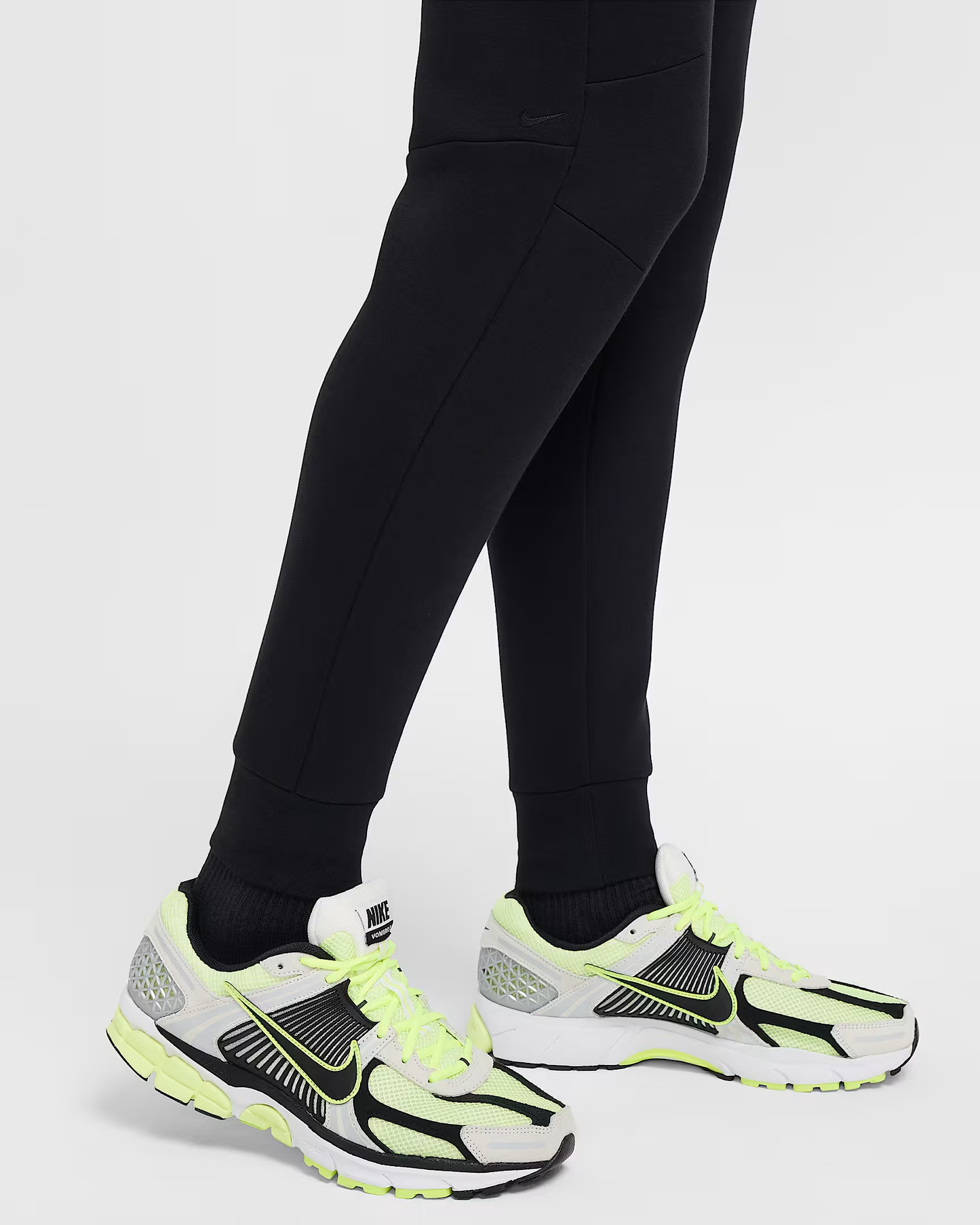 Black Nike Tech Fleece Mens Joggers with ribbed cuffs and subtle Nike swoosh logo worn with sneakers.