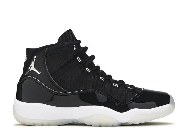 Black Air Jordan 11 kids sneaker with patent leather mudguard, white sole, and silver Jumpman logo.