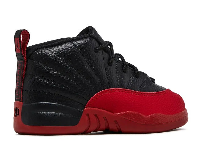 Air Jordan 12 Infants Bred sneaker, black textured upper, red toe overlay & outsole. Side view.