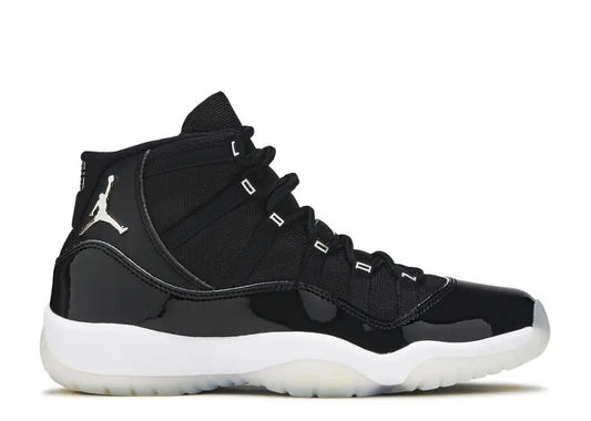 Black Air Jordan 11 kids sneaker with patent leather mudguard, white sole, and silver Jumpman logo.